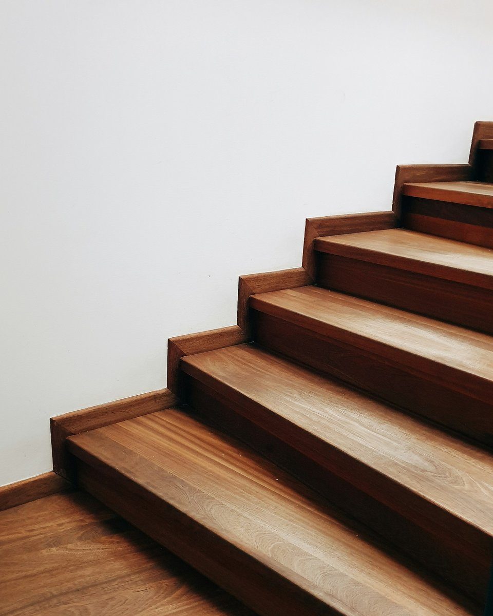 Marches d'escalier en bois qui montent le long d'un mur blanc